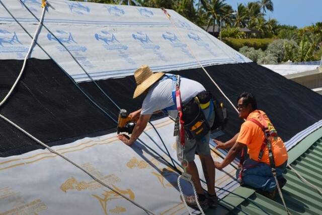 Roofing worker on new method installing metal roof